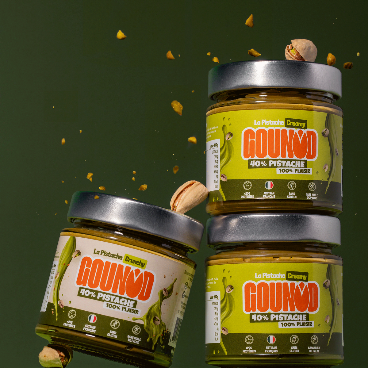 3 pots de pâte à tartiner pistache Gounod empilés, versions Creamy et Crunchy, avec éclats de pistache en suspension.